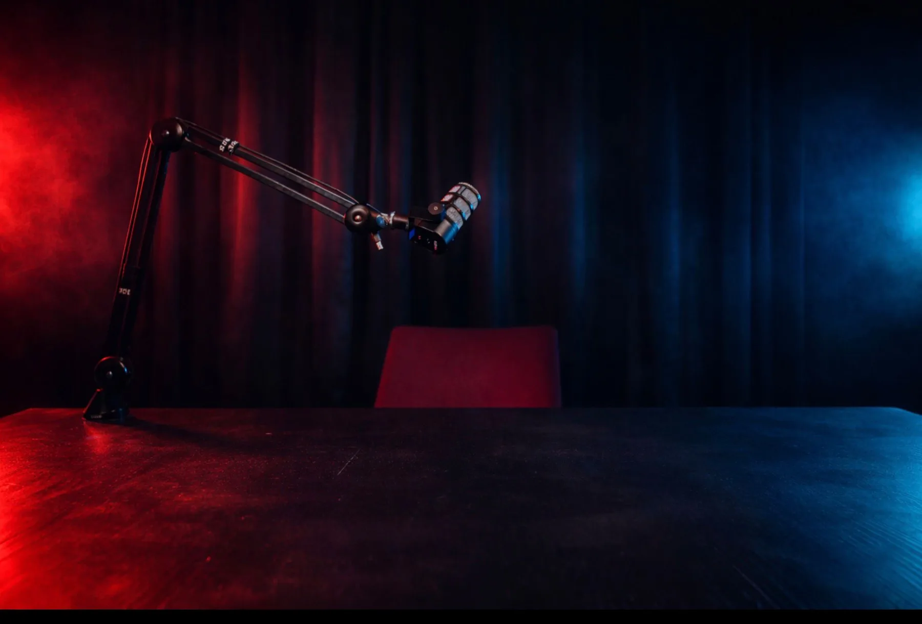 Studio Nox : bureau noir, micro sur perche, néons rouge et bleu