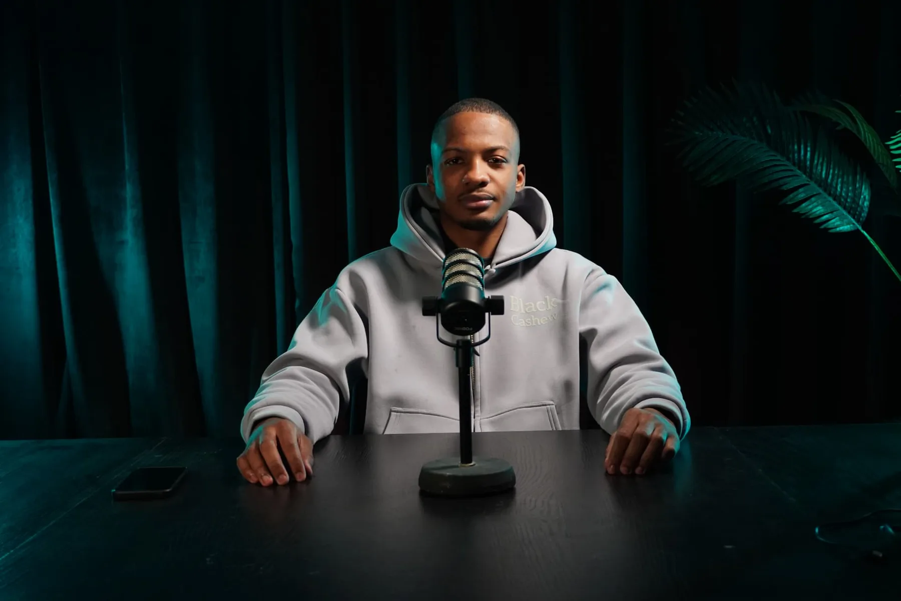Invité au micro dans le studio Podmaster, lumière teal